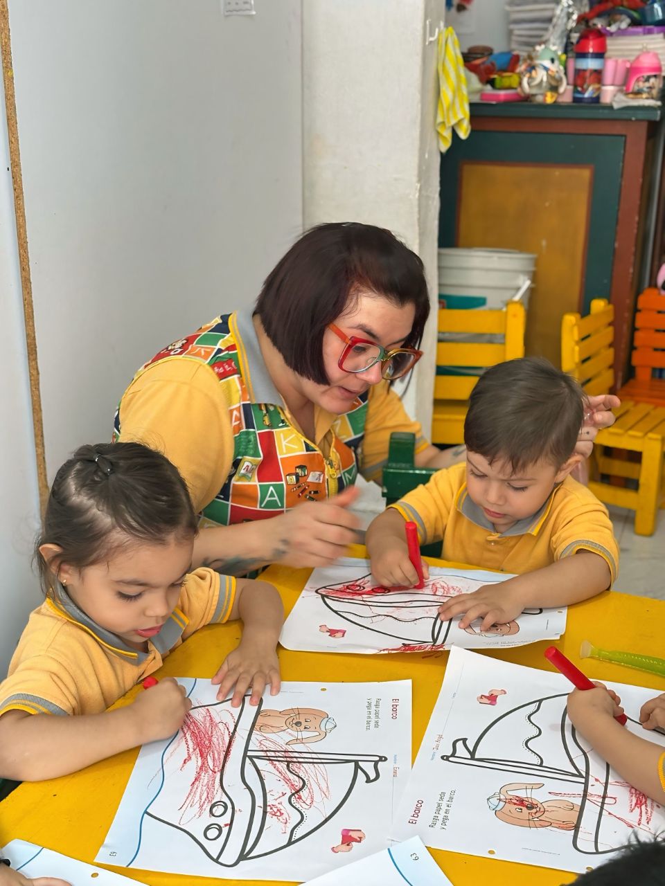 Docente de Caracolitos acompañando a niños en actividad de arte